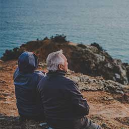 Elderly couple outdoors looking out over a lake