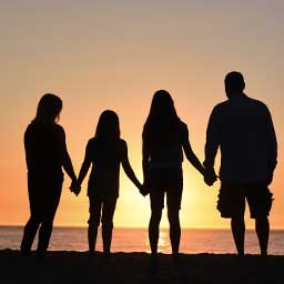 Silhouette of a family of four on a seashore